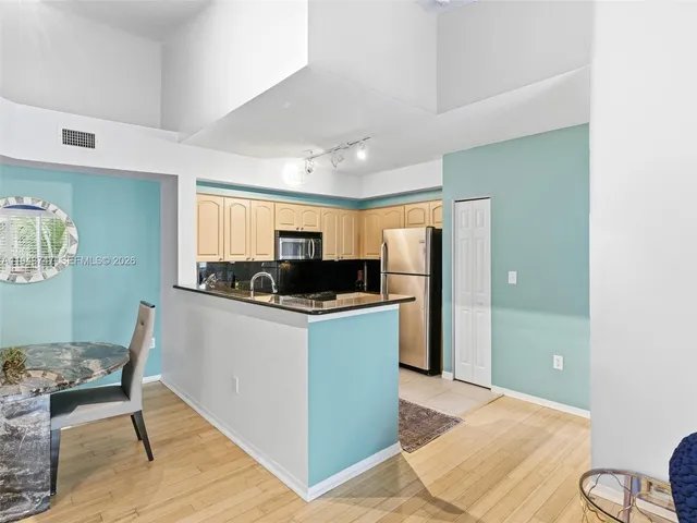 a kitchen with stainless steel appliances granite countertop a refrigerator and a stove top oven