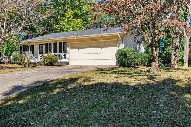 a view of a house with a big yard and large tree