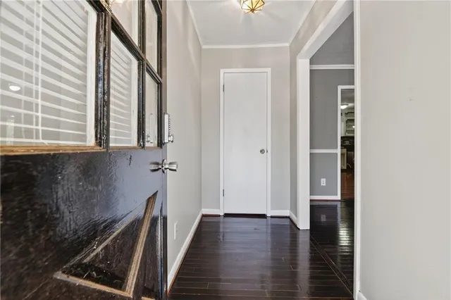 a view of a hallway with wooden floor and staircase