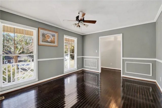 a view of a livingroom with wooden floor and a ceiling fan