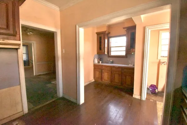 a view of a hallway with wooden floor and a living room