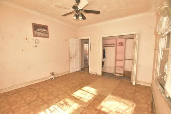 a view of a livingroom with a chandelier fan and closet area