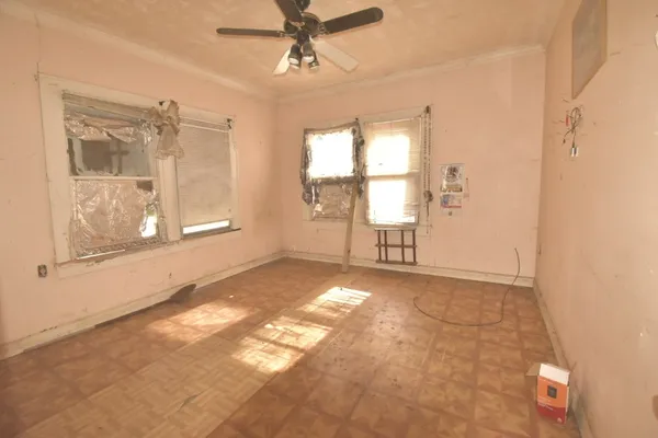 an empty room with windows and fan