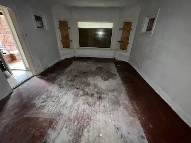 a view of a hallway with wooden floor and stairs
