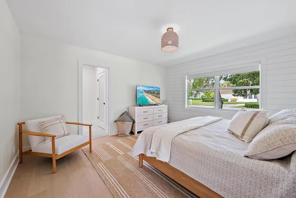 a bathroom with a granite countertop sink a toilet a mirror and shower