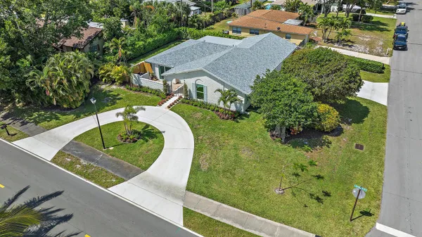 a view of house with garden and tall tress