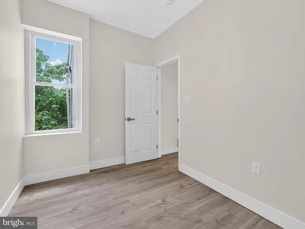 an empty room with wooden floor and window