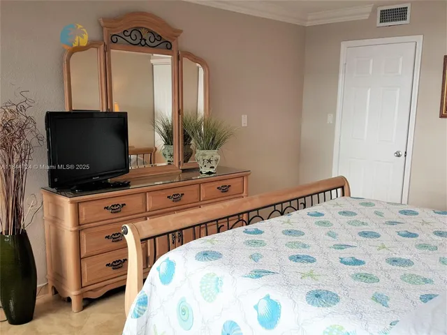 a bedroom with a bed and flat screen tv