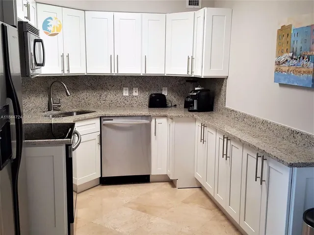 a kitchen with stainless steel appliances granite countertop a sink a stove and a microwave