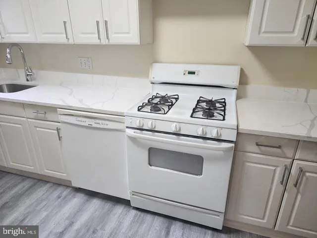 a kitchen with white cabinets and appliances