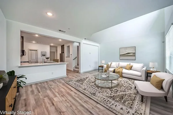 a living room with furniture and a wooden floor