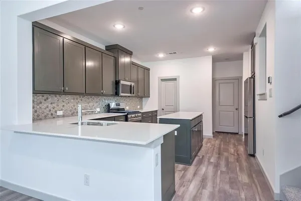 a large kitchen with kitchen island a sink stainless steel appliances and cabinets
