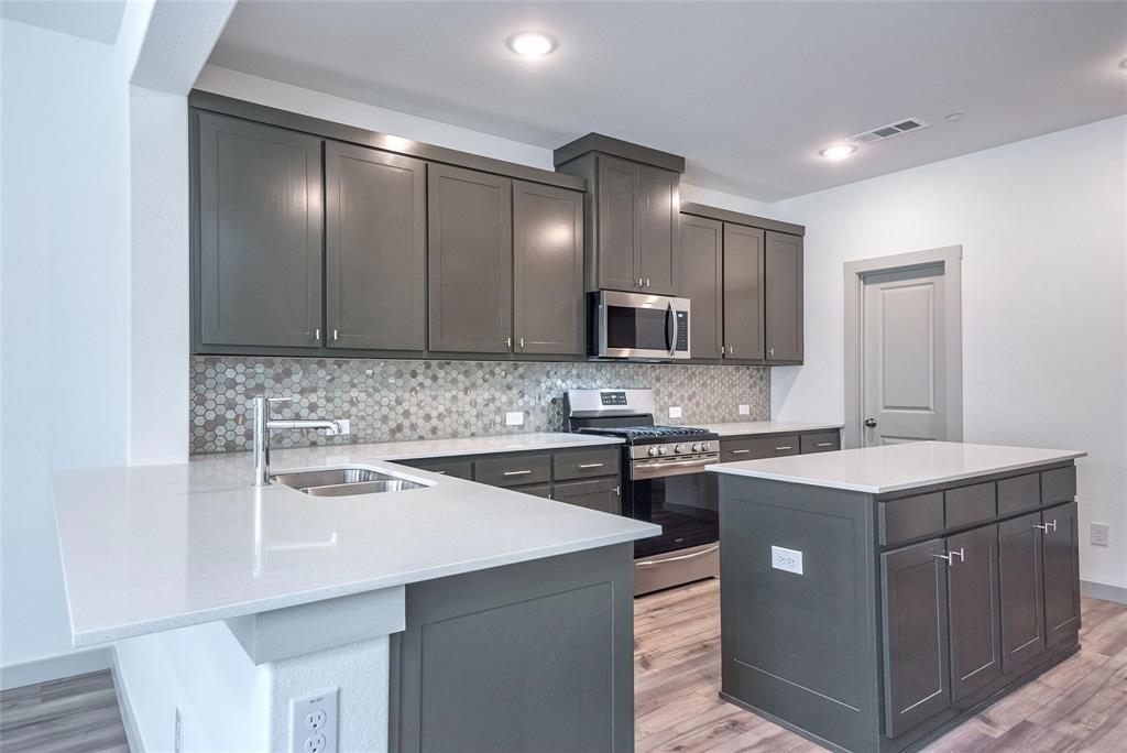 692 Vista Oak Road Lewisville, TX 75067 - Photo 12 of 39 a kitchen with a sink stove and microwave