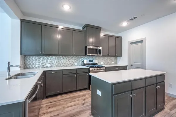 a kitchen with a sink stove and cabinets