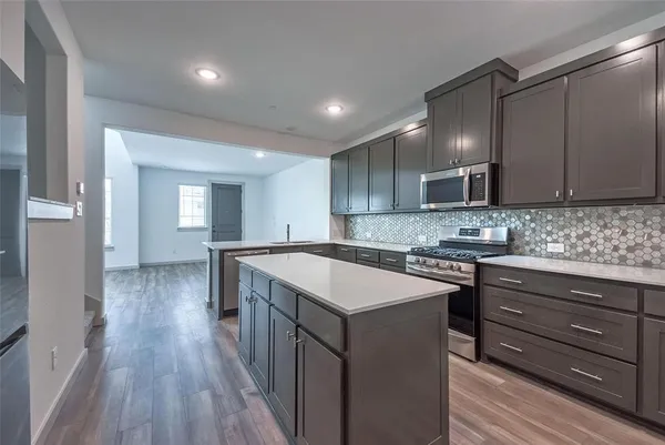 a kitchen with wooden cabinets and stainless steel appliances