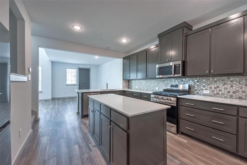 692 Vista Oak Road Lewisville, TX 75067 - Photo 14 of 39 a kitchen with wooden cabinets and stainless steel appliances
