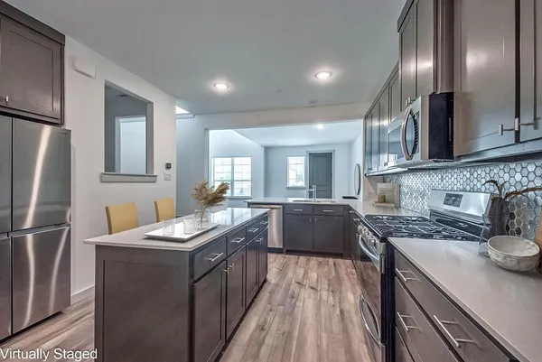 a kitchen with granite countertop a sink stainless steel appliances and cabinets