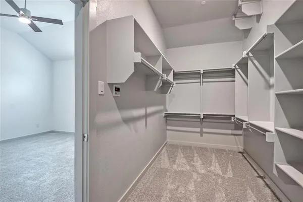 a view of walk in closet with empty racks