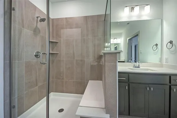 a bathroom with a sink a toilet a mirror and shower