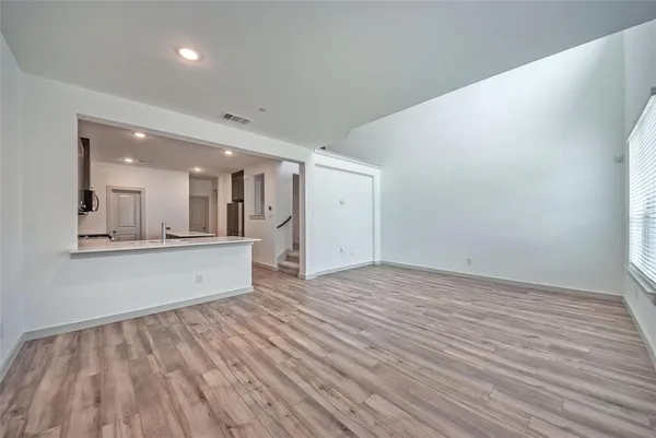 a view of a big room with wooden floor and windows
