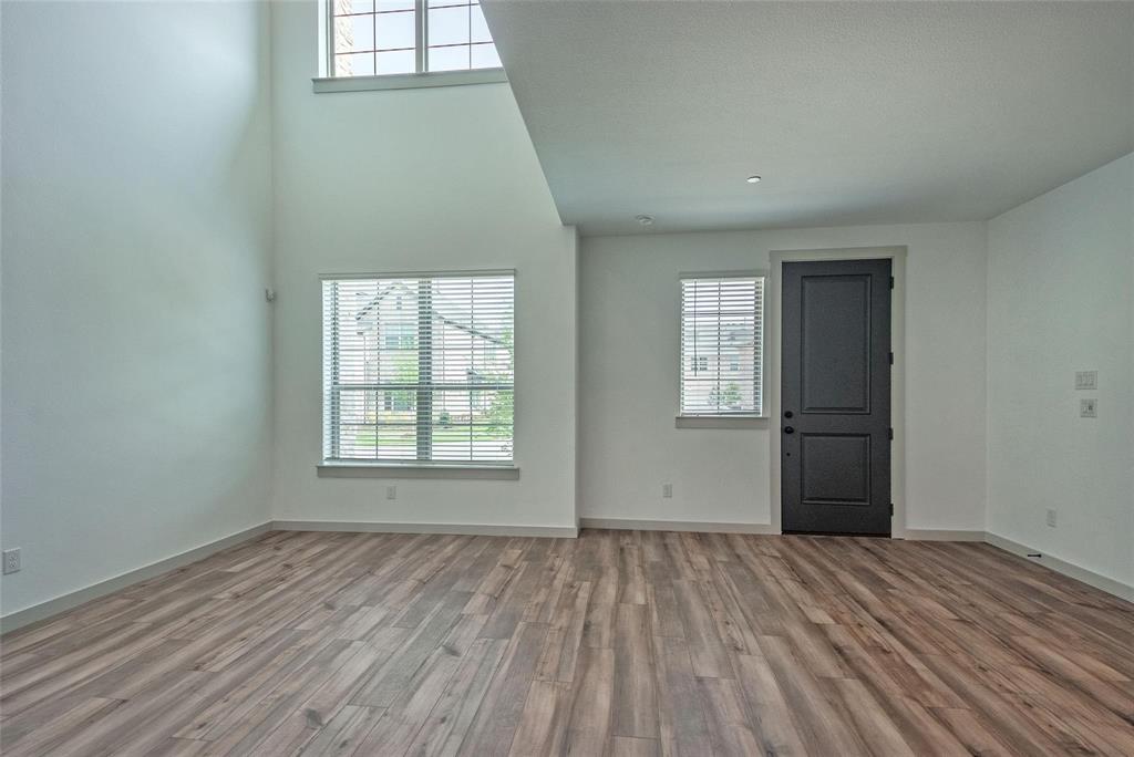 692 Vista Oak Road Lewisville, TX 75067 - Photo 10 of 39 an empty room with wooden floor and windows