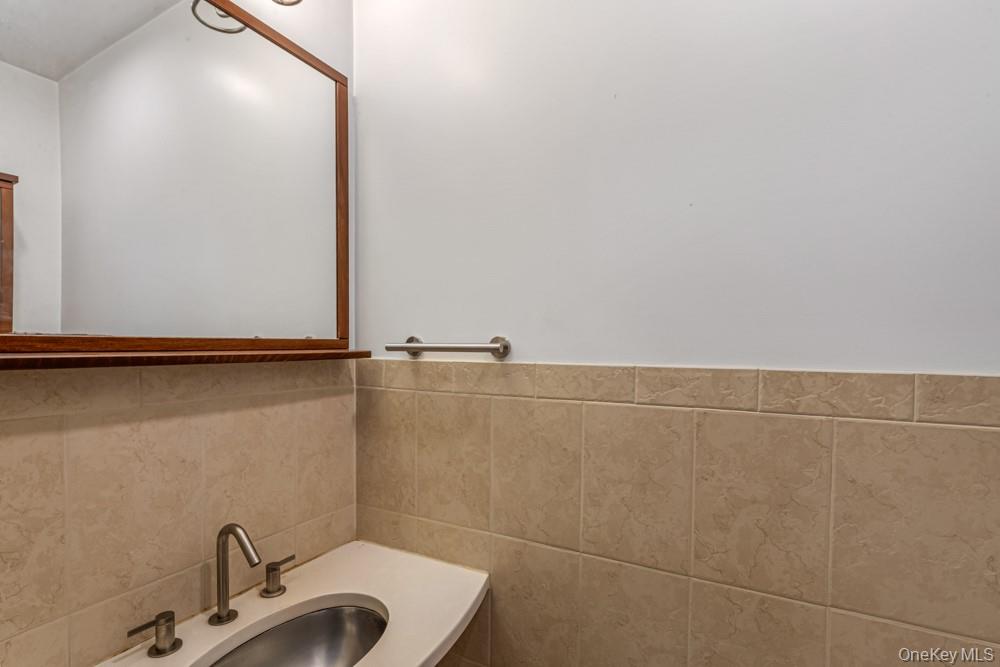 1 Virginia Road Syosset, NY 11791 - Photo 14 of 16 a bathroom with a sink and mirror