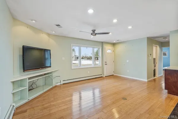 a view of a livingroom with wooden floor and a flat screen tv