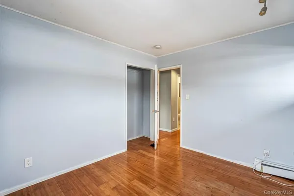 a view of an empty room with wooden floor