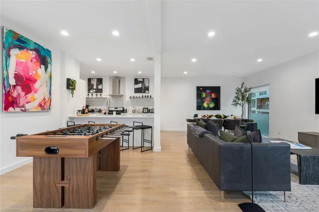 a living room with stainless steel appliances furniture stove and cabinets