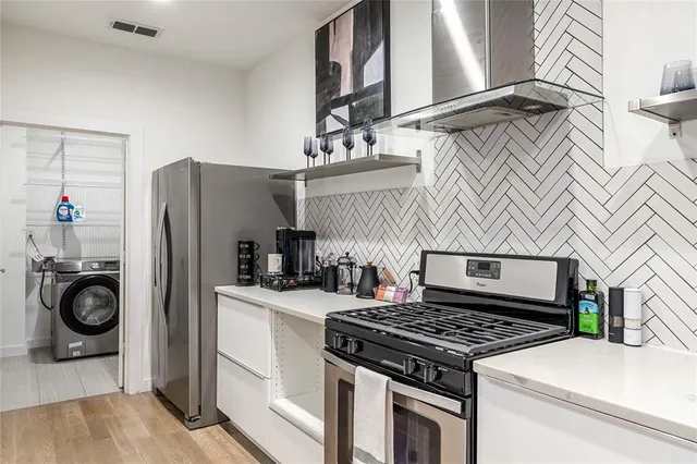 a kitchen with stainless steel appliances granite countertop a stove and a refrigerator
