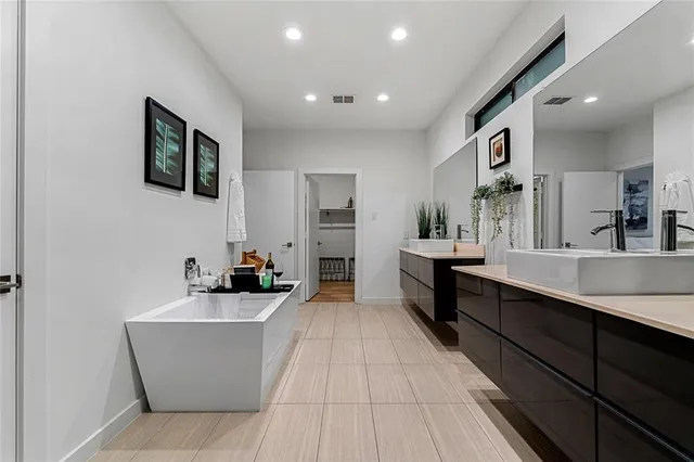 a large living room with stainless steel appliances kitchen island a sink a stove and a large mirror