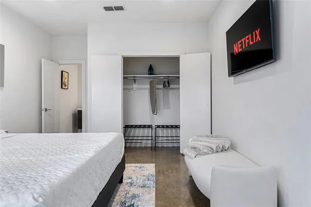 a bedroom with furniture and a flat screen tv