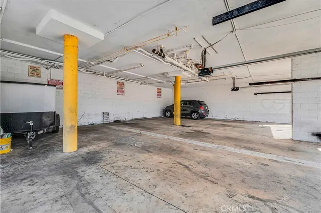 a view of an empty room with window and chandelier fan