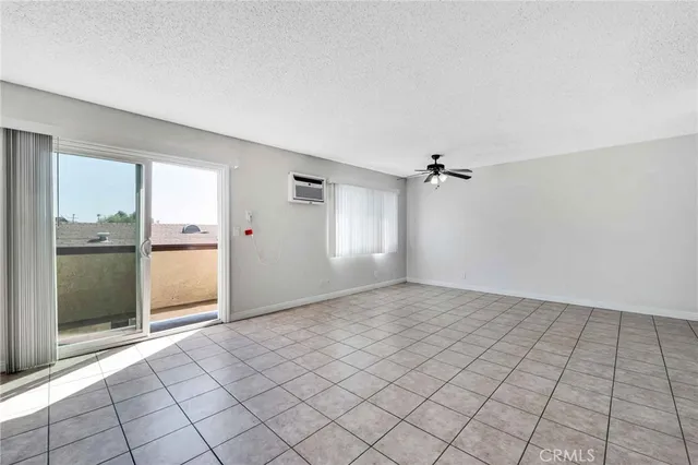 a view of empty room with window and chandelier fan