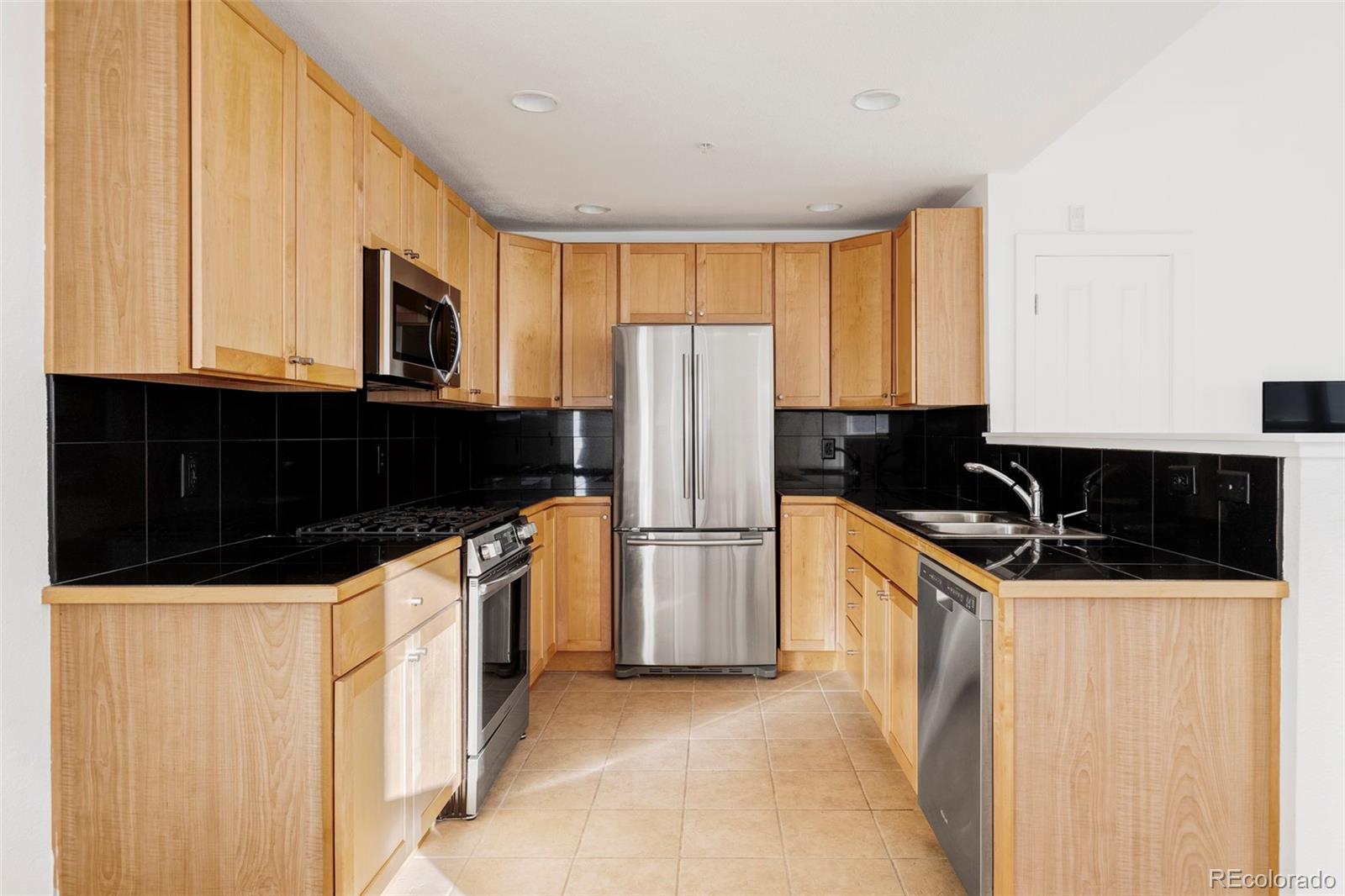 3265 Foundry Place, Unit 101O Boulder, CO 80301 - Photo 11 of 36 a kitchen with granite countertop a refrigerator a stove a sink and dishwasher
