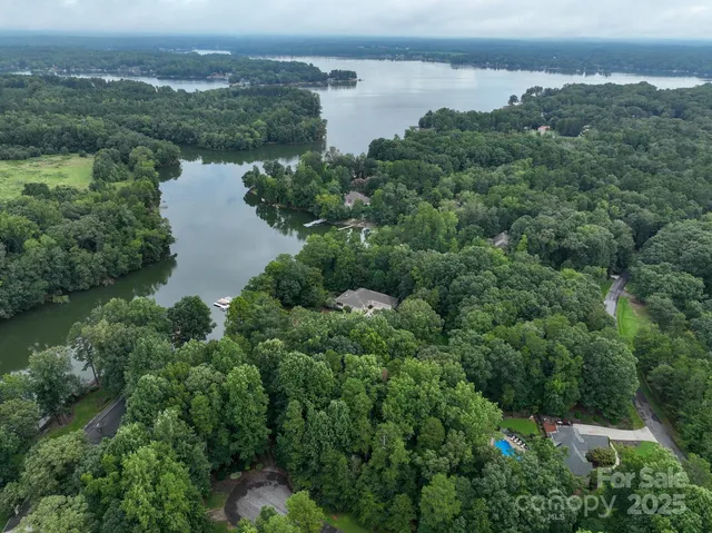 a view of house and outdoor space with swimming pool and trees