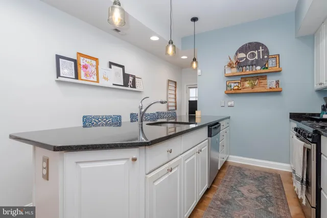 a kitchen with stainless steel appliances granite countertop a sink and a refrigerator