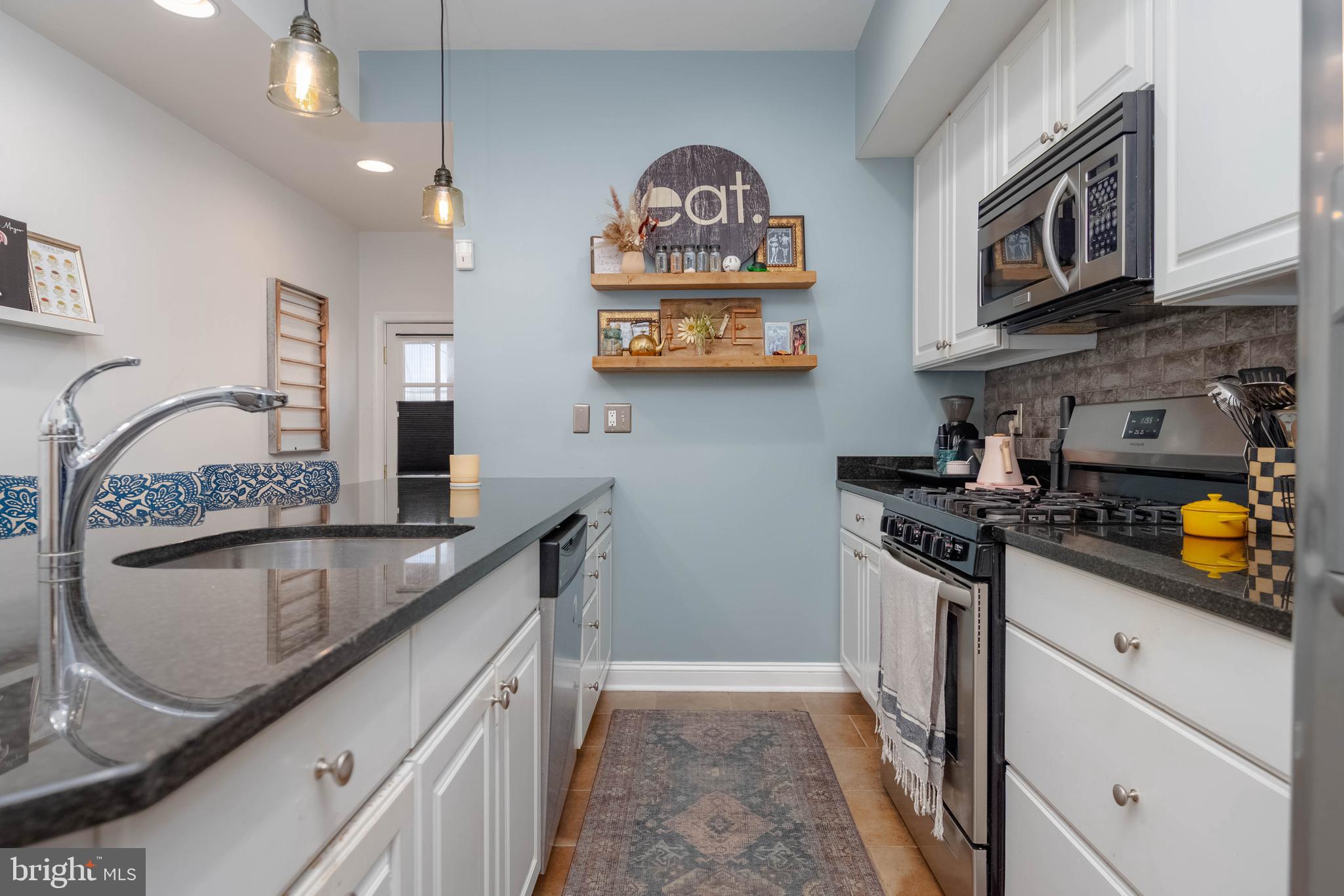318 South Duncan Street Baltimore, MD 21231 - Photo 7 of 27 a kitchen with stainless steel appliances granite countertop a sink stove and refrigerator