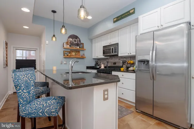 a kitchen with stainless steel appliances granite countertop a sink refrigerator and microwave