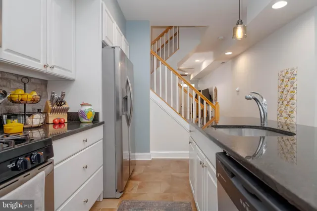 a kitchen with granite countertop a refrigerator a stove and a sink