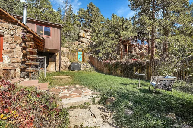 a view of a barn with large trees and plants