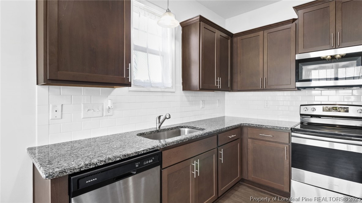 217 Fieldbrook Street Raeford, NC 28376 - Photo 13 of 42 a kitchen with stainless steel appliances granite countertop a sink stove and cabinets