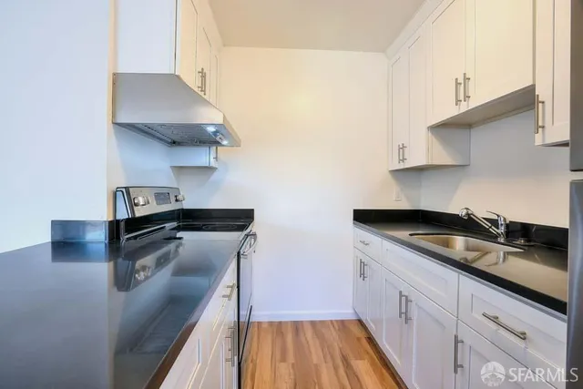 a kitchen with granite countertop a sink and a stove
