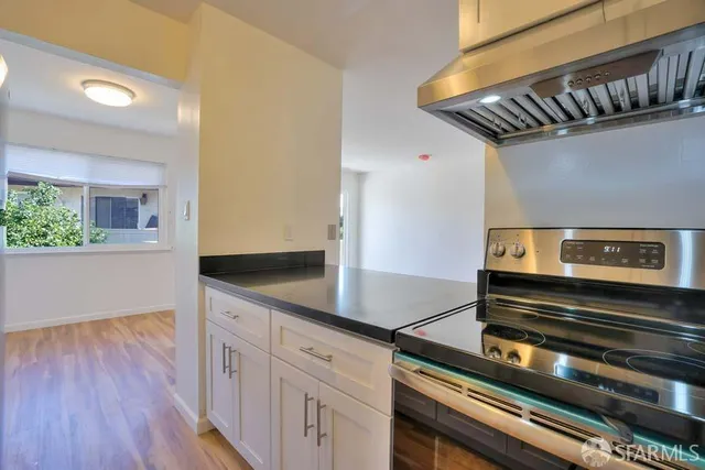 a kitchen with kitchen island wooden floor and appliances