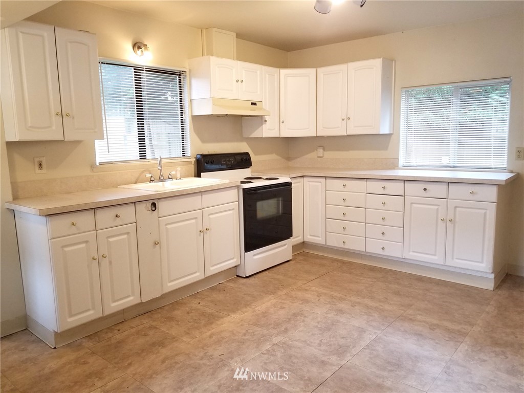 2321 Rucker Avenue Everett, WA 98201 - Photo 6 of 12 a kitchen with white cabinets white stainless steel appliances and sink
