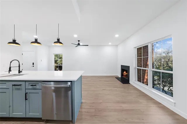 a kitchen with stainless steel appliances granite countertop a sink a stove and a wooden floors
