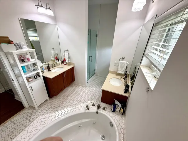 a bathroom with a tub sink and mirror