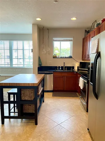 a kitchen with stainless steel appliances granite countertop a stove a sink and a refrigerator