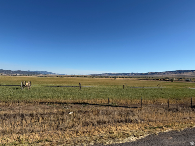 126 Burraston Road, Unit 2 Mona, UT 84645 - Photo 3 of 7 Expansive agricultural field with an irrigation system, bordered by distant mountains