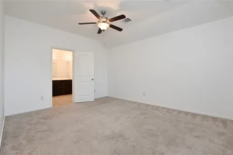 an empty room with ceiling fan and window